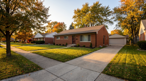 Brick single-family rental home on a tree-lined Metro Detroit street in autumn
